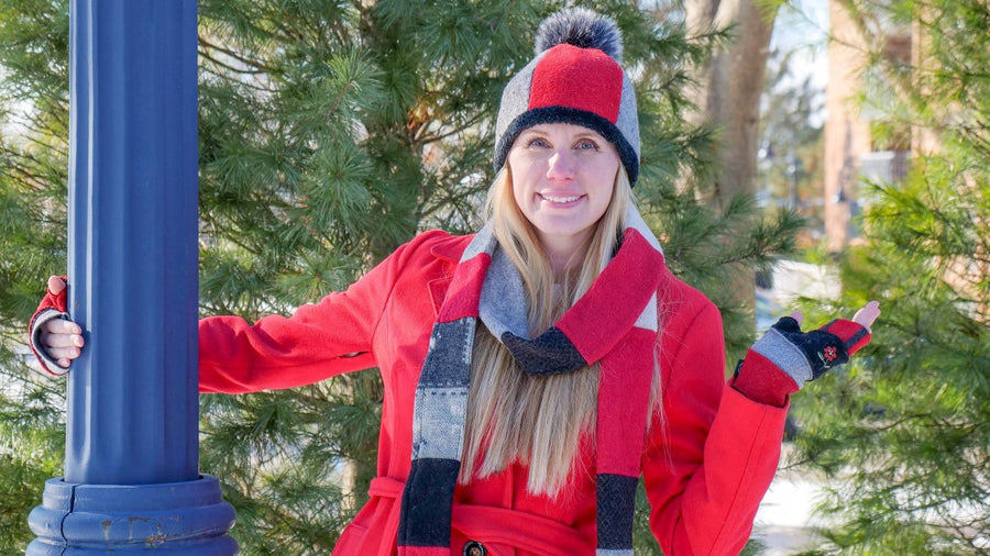 Woman wearing red wool pom pom hat, skinny scarf and sweater mittens