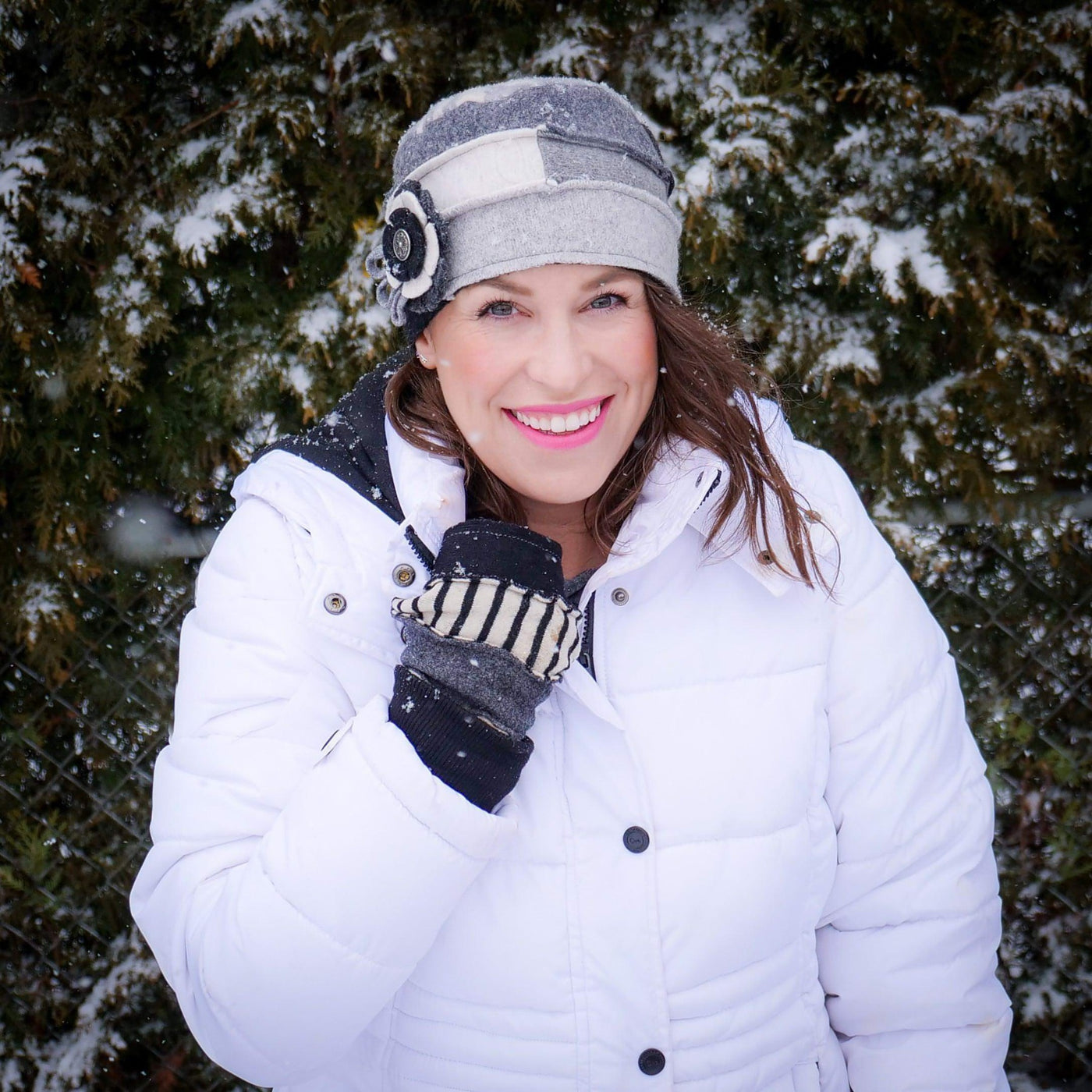 black and white cloche hat and fingerless gloves on woman wearing white winter coat