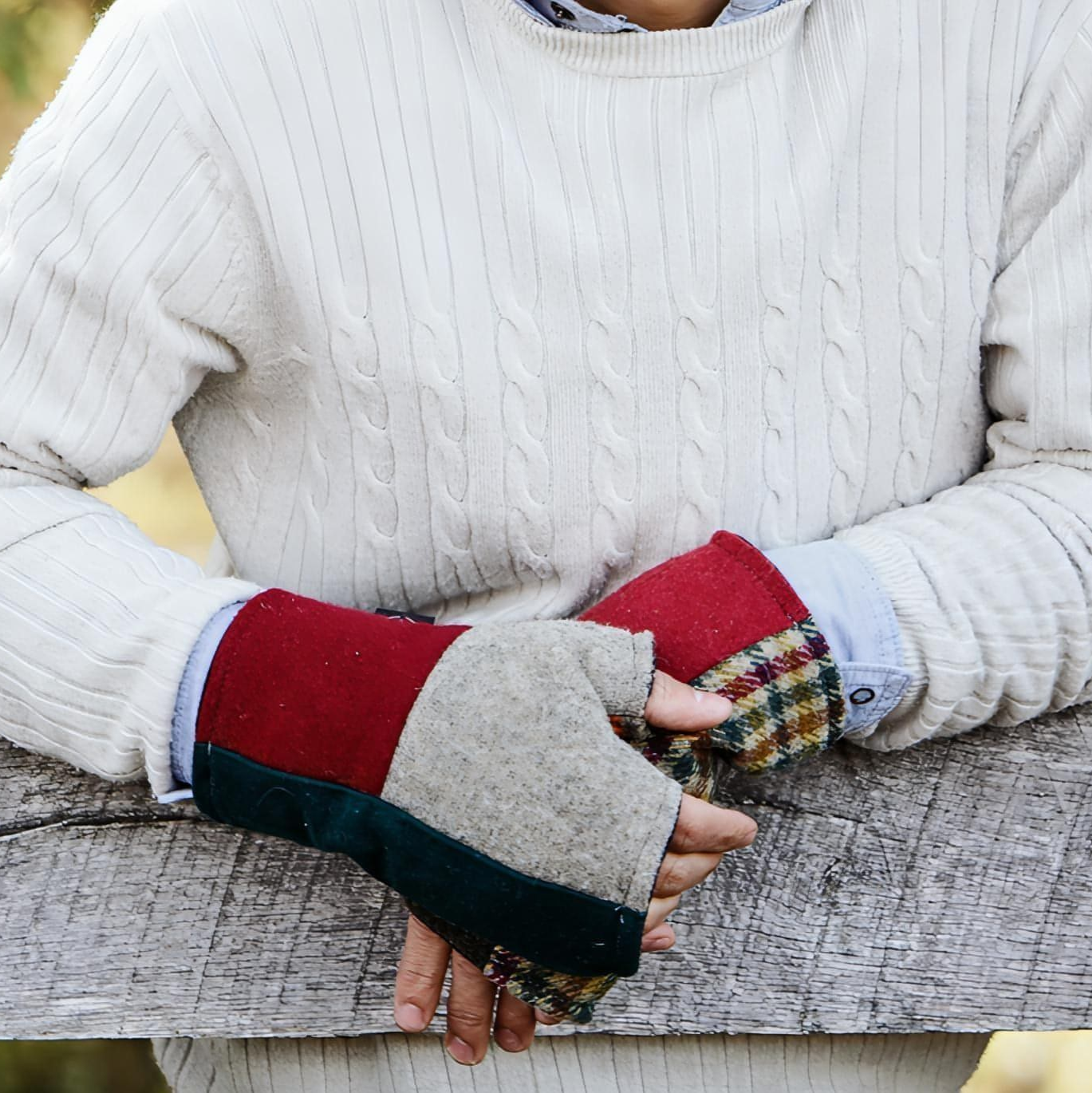 man leaning on fence wearing wool fingerless gloves