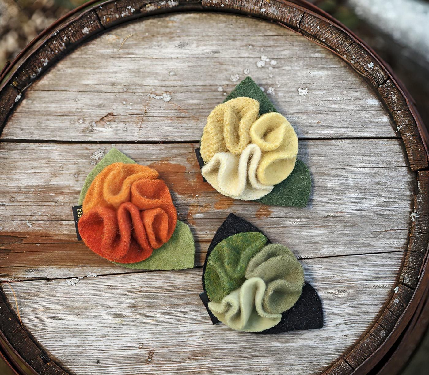 three mumsy pins on a wood barrel